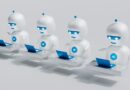 a group of white robots sitting on top of laptops