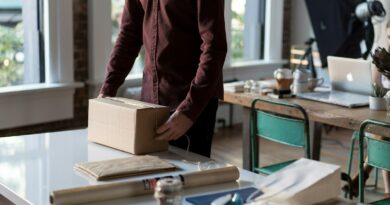 person holding cardboard box on table